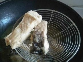 锅内入油，用厨房纸擦干鱼块，裹蛋液淀粉，炸至表皮起酥，捞出待用