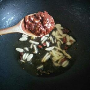 锅内留一部分油，放入大蒜，姜，泡椒，稍微炒一会至姜变色，加入豆瓣酱，转小火，炒出红油即可（不吃辣的可以不放）