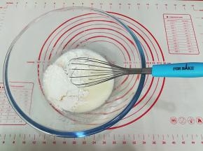 把低筋面粉分次加入打蛋盆中，搅拌至看不见干粉