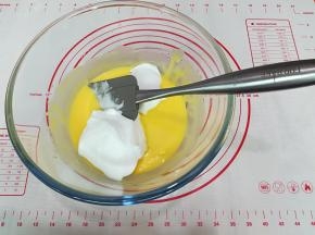 将1/2的蛋白霜倒入蛋黄糊中，用手动打蛋器从盆底由下向上快速翻拌