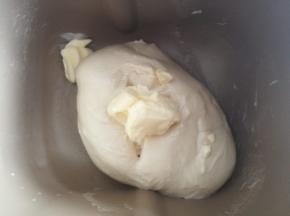 揉至十分钟，面团光滑后加入黄油，继续揉面。