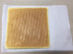 蛋糕晾凉至还有余温时，把油纸撕去，盖上一张新的油纸，然后翻面，正面朝上