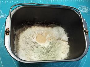 面包桶内先后加入清水，鸡蛋液，白糖和盐（白糖和盐放对角），加入高粉，奶粉和酵母，面包机选择“和面”程序。