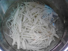 金针菇切去根部，用沸水焯烫至软，浸入冷水过凉