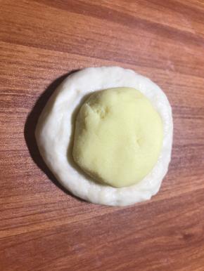 按扁面团排气，放入馅球包好