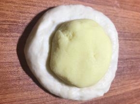 按扁面团排气，放入馅球包好