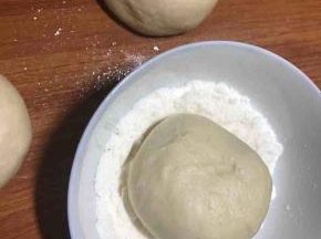 粘少许椰子粉在表面（这步可省略）然后放入烤盘进行二次发酵，稍微变大即可。