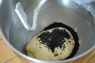 揉至面团出膜加入黑芝麻继续揉至混合面团均匀。