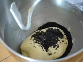 揉至面团出膜加入黑芝麻继续揉至混合面团均匀。