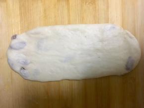 取面团，用擀面杖擀成椭圆形，从一侧卷起