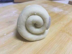 再次擀成椭圆形，从一侧卷起，两圈半的长度