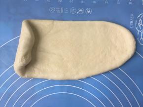 把面团擀开成舌形，由下往上卷起来