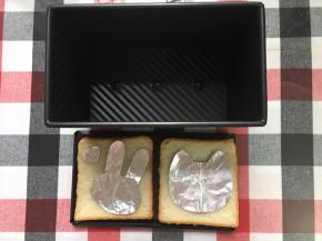 切2片吐司，剪出萌萌哒的锡纸盖在吐司上，然后放烤箱最上层里200烤5分钟左右上色