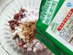 肉馅和洋葱蒜瓣放在容器里加入酷克壹佰的调料搅拌均匀、