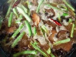 倒入清水没过豆角表面，然后加盖用中火焖至汤汁烧开，