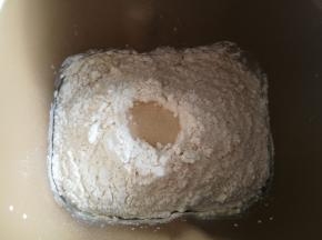 面团原料除黄油外都放入面包机桶，启动面包机和面功能。