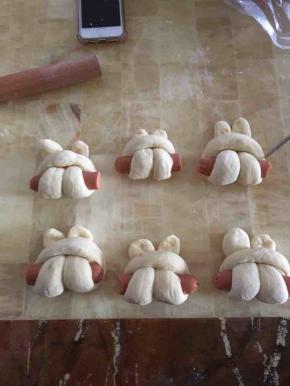 然后做一个u型，放一根火腿肠！然后返穿回去，之后放在烤盘发到2倍大！时间约30分钟！也可以到烤箱二发，放一碗水到烤箱里二发也是很快的哦！