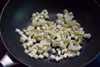 再起油锅，将茭白丁煸炒干水分开始变焦黄