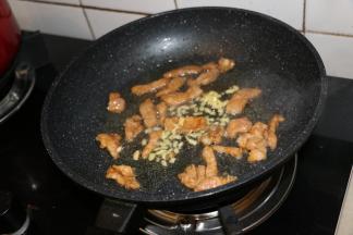 锅内倒入适量食用油，滑入肉片煸炒至变色，放入姜末。腌制后的猪肉特别滑嫩。