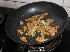 锅内倒入适量食用油，滑入肉片煸炒至变色，放入姜末。腌制后的猪肉特别滑嫩。