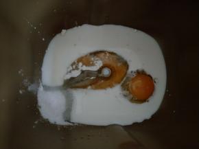 面包机先放入鸡蛋、牛奶，盐和糖对角放，接着放高粉、高粉中间挖个洞放酵母。