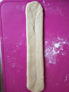 继续从中间开始，往上下两个方向擀长，注意底部要压薄。