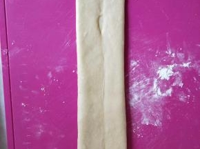 继续从中间开始，往上下两个方向擀长，注意底部要压薄。