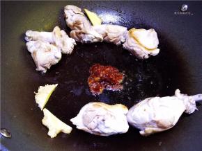 将鸭肉拨至锅边，中间放入少许油，将郫县豆瓣酱放入炒出红油。