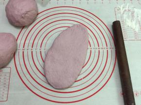 10. 取一个松弛好的面团，擀开边上的气泡拍掉，翻面，自上往下卷起