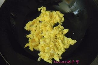 炒锅内倒入食用油将鸡蛋炒散；