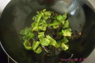 放入青椒块和水发木耳翻炒；