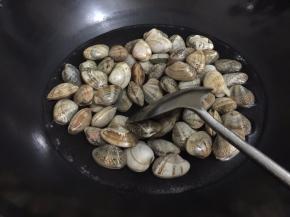 3. 锅里坐水烧开，把洗净的花甲王烫到开口，这样烫是缩短炒制的时间，也可以去掉一些花王里面的沙子