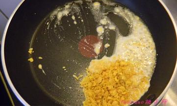 平锅内放入食用油，油温五成热放入擀碎的咸蛋黄，煸炒；
