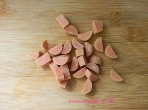 将火腿肠剥去外皮，对半切开，再切小丁；
