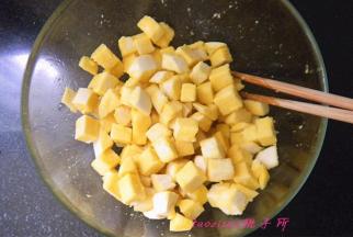 将蛋液打散后，倒在馒头丁上拌匀，让每粒馒头都沾上蛋液；