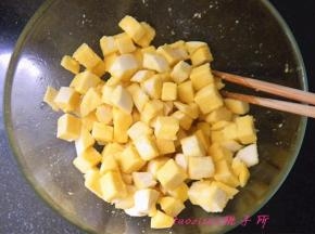 将蛋液打散后，倒在馒头丁上拌匀，让每粒馒头都沾上蛋液；