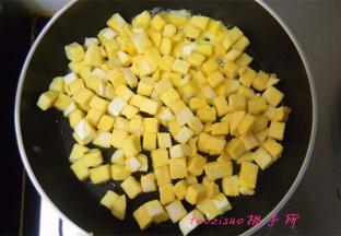 平锅里倒入食用油，倒入拌好蛋液的馒头丁，将馒头丁煎至上色；
