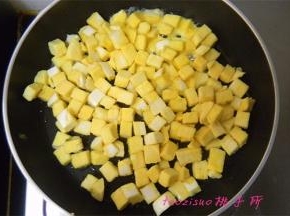 平锅里倒入食用油，倒入拌好蛋液的馒头丁，将馒头丁煎至上色；