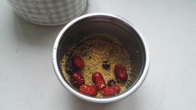 黑小米、黄小米、灰枣分别淘洗干净，桂圆去壳，全部放进饭盒最大的不锈钢容器中。