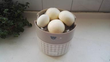 把不锈钢容器放入饭盒机体内，放上中间格层，把馒头和洗净的咸鸭蛋放入,盖上盖，两边扣上。