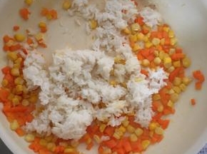 玉米和胡萝卜先用少许油炒熟，然后加入米饭炒均匀