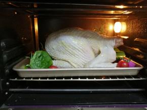 烤箱预热至210℃，将鸡放在烤箱的中间，烤盘根据鸡的位置进行调整，鸡比较大，烤的时间长一点，这只两公斤的鸡大概烤50分钟左右，中间再刷一次黄油