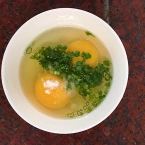 鸡蛋加入1克盐和一小把葱花，搅拌均匀