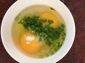 鸡蛋加入1克盐和一小把葱花，搅拌均匀