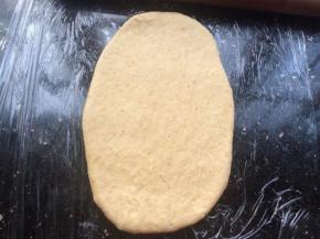 把松弛好的面团，用擀面杖擀成牛舌状。