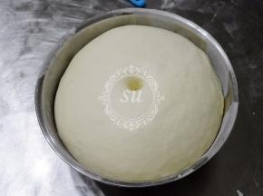 手指沾少许面粉，插入面团检测发酵状态，如图有肚脐装圆孔，略有回缩的时候，一发完成