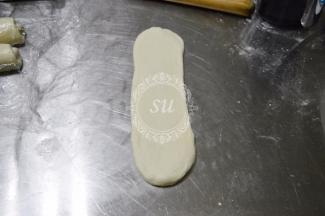 松弛好的面卷从中间位置上下擀开擀长