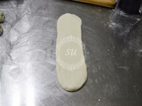 松弛好的面卷从中间位置上下擀开擀长