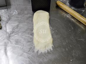 翻面，依旧是底部抹薄。可以用吐司盒来比对一下，卷的宽度要比吐司盒略小一些。
