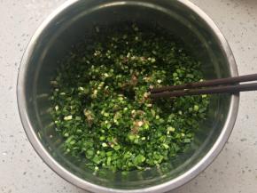 将韭菜和姜末加入肉馅中，倒入玉米油和香油